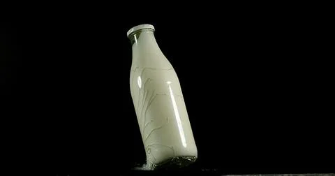 Bottle of Milk Exploding against Black Background Foto stock
