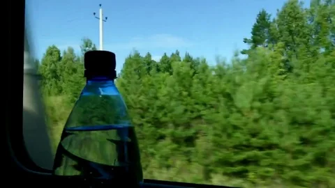 Bottle with mineral water at the window of the train car. Timelapse. Stock Footage 79371248
