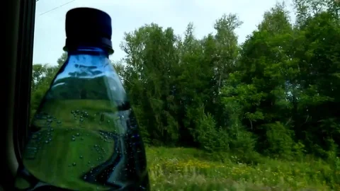 Bottle with mineral water at the window of the train car-2. Timelapse. Stock Footage 79371296