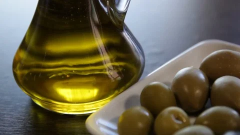 A bottle of olive oil and different types of olives on a plate. Stock Footage 112538997