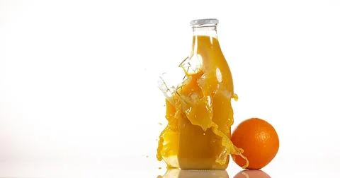 Bottle of Orange Exploding against White Background Stock Photos