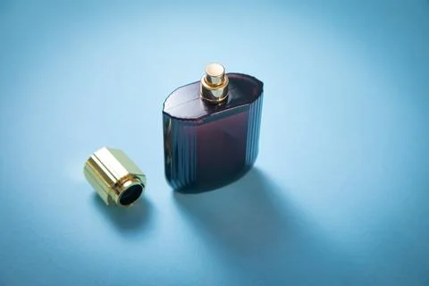 Bottle of perfume on the blue background. Stock Photos