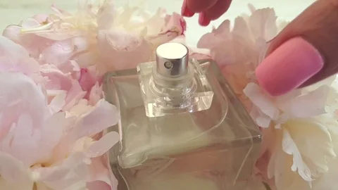 Bottle of perfume female hand fresh peony slow motion Stock Footage 109341053