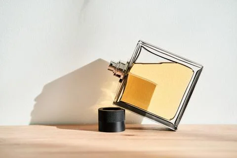 A bottle of perfume in the rays of the sun. Stock Photos