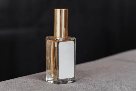 A bottle of perfume spray with a label for text on a dark background Stockfoto's