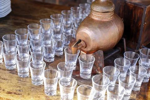 Bottle with pinga and several small glass glasses Stock Photos