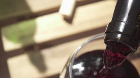 From the bottle pouring wine into a glass on the table slow motion Video stock 88915794