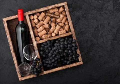 Bottle of red wine and empty glasses with dark grapes with corks and opener i Foto stock