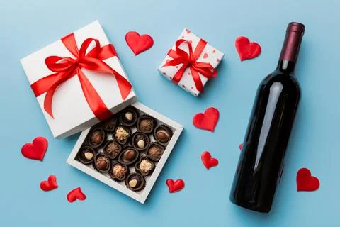 Bottle of red wine on colored background for Valentine Day with gift and choc Stock Photos
