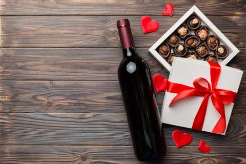 Bottle of red wine on colored background for Valentine Day with gift and choc Stock Photos