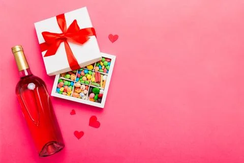 Bottle of red wine on colored background for Valentine Day with gift and ch.. Stock Photos