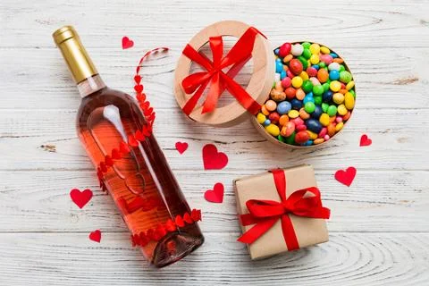 Bottle of red wine on colored background for Valentine Day with gift and choc Stock Photos