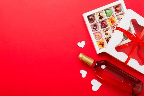 Bottle of red wine on colored background for Valentine Day with gift and ch.. Stock Photos