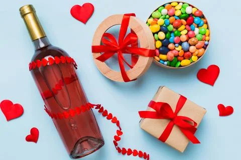 Bottle of red wine on colored background for Valentine Day with gift and choc Stock Photos