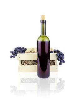 Bottle of red wine with cork in front of wooden box with two bunches of grape Stock Photos