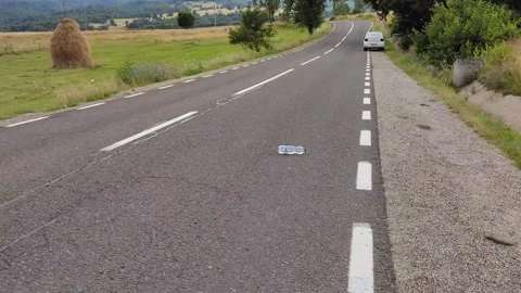 A bottle rolls seemingly up the hill, antigravitional hill Stock Footage 246878721