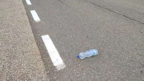 A bottle rolls seemingly up the hill, antigravitional hill Stock Footage 246878766