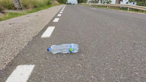 A bottle rolls seemingly up the hill Stock Footage 246878700