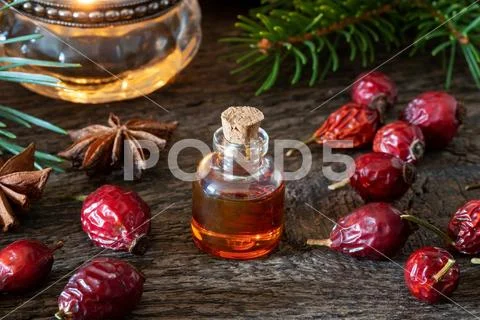 A bottle of rose hip seed oil with dried rose hips Stock Photos