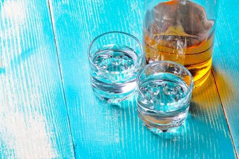 The bottle of rum on the blue table there are two Stock Photos