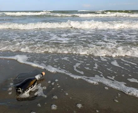 Bottle with a secret message inside on the beach without people Fotos de archivo