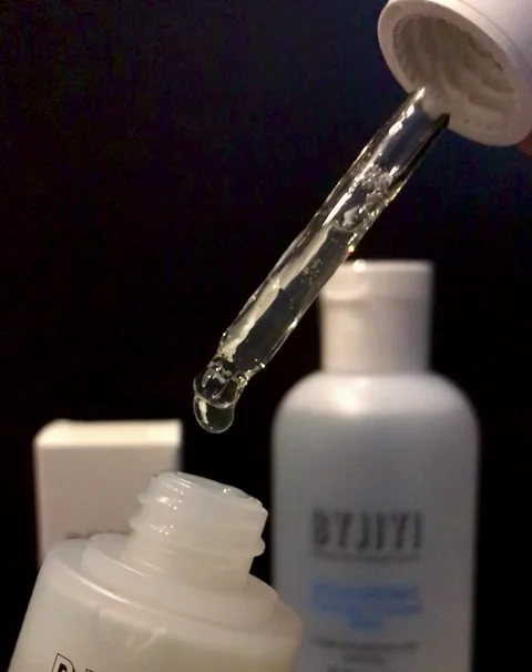 Bottle of serum and gel Flat lay. Liquid gel or serum drop with pipette on black Stock Footage 246981213