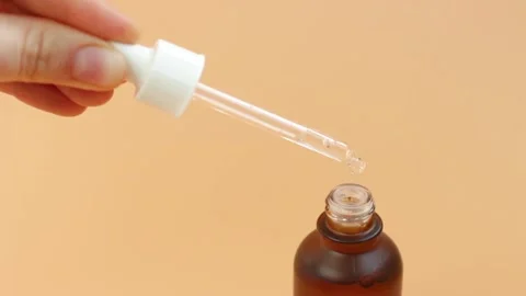 Bottle with serum and pipette on brown background close-up. Stock Footage 150533732
