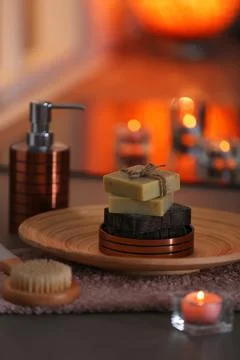 Bottle of shampoo and soap bars on table against blurred background 스톡 사진