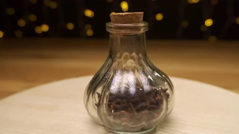 Bottle for spices with cork cap on a dark background with light decoration Stock Footage 222922758
