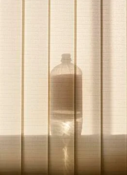 The bottle standing on the window casts a shadow Stock Photos
