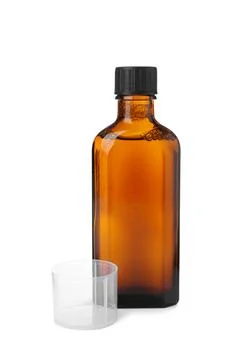 Bottle of syrup with measuring cup on white background. Cough and cold medici Stock Photos