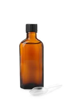Bottle of syrup with plastic spoon on white background. Cough and cold medici Stock Photos