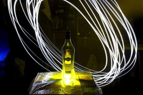 Bottle of vodka on the table in the dark with light painting Stock Photos