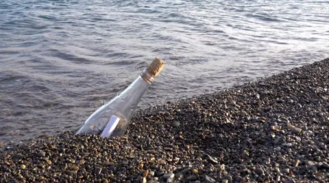 Bottle washed up by waves with a letter in it Stock Footage 67998929