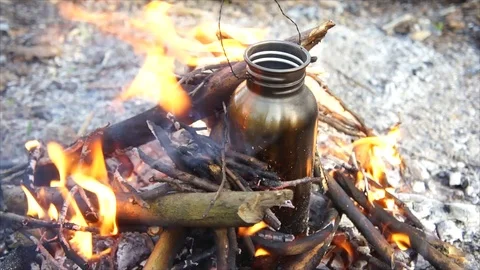 Bottle of Water Boiling over Campfire. Camping in Forest Stock Footage 109680220