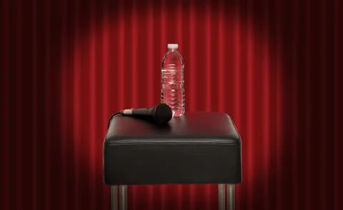 Bottle of water next to a microphone on a stool in the stage Stock Photos
