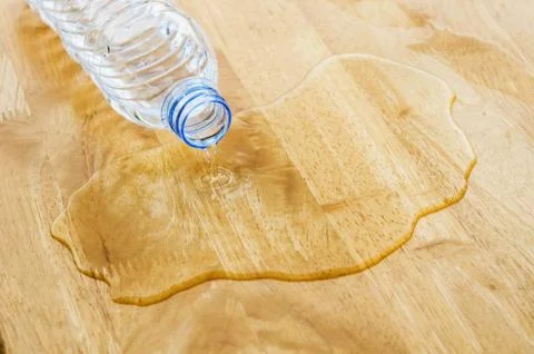 Bottle of water overflows over the table. Stock Photos