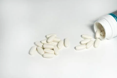 Bottle with white oval pills Stock Photos