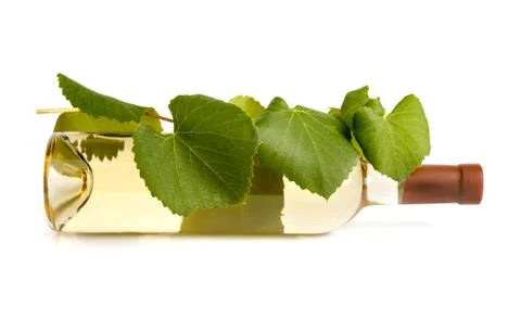 A bottle of white wine on the side with grape leaves Foto stock