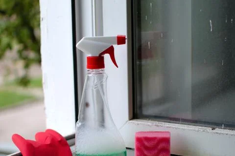 Bottle of window cleaner on dirty window Stock Photos
