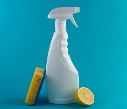 Bottle of window spray, sponge, lemon on blue background Stock Photos