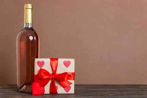 Bottle of wine on colored background for Valentine Day with gift box. Heart.. Stock Photos