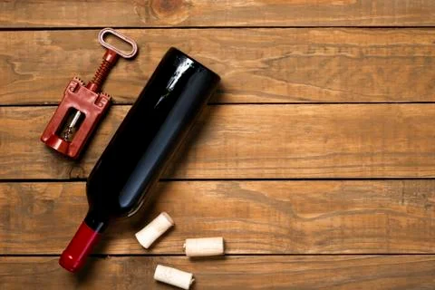 Bottle of wine corkscrew and corkscrew on wooden background. Top view with co Stock Photos