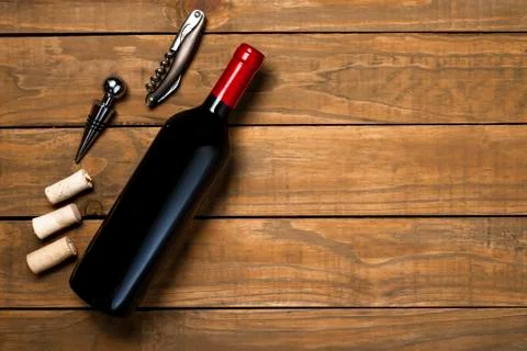 Bottle of wine corkscrew and corkscrew on wooden background. Top view with co Stock Photos