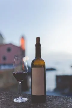Bottle of wine with glass on the beautiful beach at the evening Italy. Wine i Stock Photos