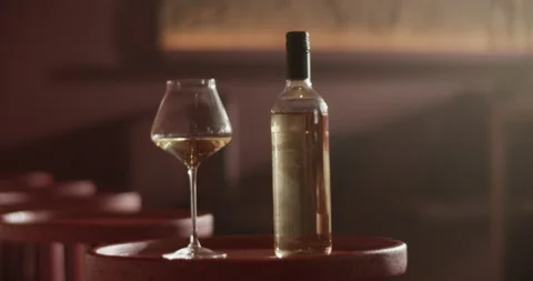Bottle of wine placed on round table with wineglass Stock Footage 239166483