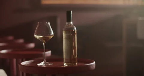 Bottle of wine placed on round table with wineglass Stock Footage 239168342