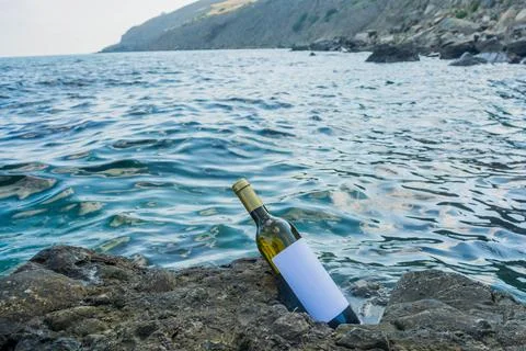 Bottle of wine on the seashore Stock Photos