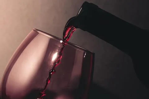 A bottle of wine serving wine in a cup with copy space in time stop with co.. Stock Photos