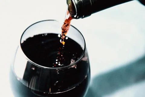 A bottle of wine serving wine in a cup with copy space in time stop with co.. Stock-Fotos
